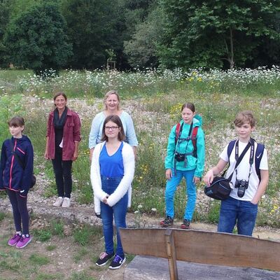 Bild vergrößern: Eine Gruppe von 6 Kindern steht vor einer Wildblumenwiese